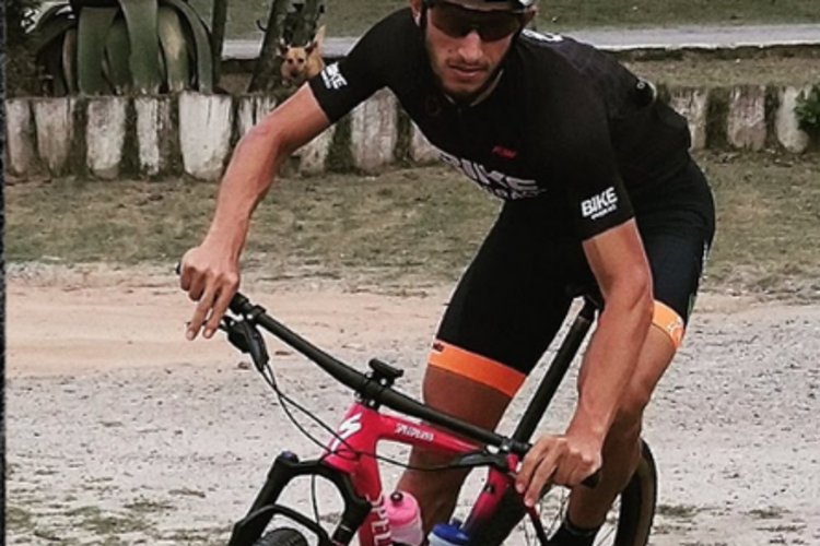 Vitor Gustavo pedalando de mountain bike em trilha de terra